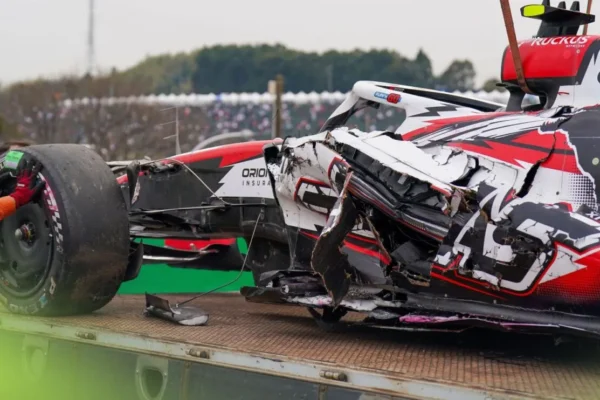 Oliver Bearman's damaged Haas VF-26 sits against the barriers at Suzuka's Spoon Curve following his 50G crash during the 2026 Japanese Grand Prix, with marshals approaching the wreckage.