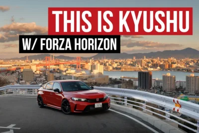 A red Honda Civic Type R FL5 parked on a scenic overlook in Kitakyushu, Japan, with the Wakato Bridge and the city's harbour skyline stretching across the golden-hour horizon behind it, shot during a Forza Horizon collaboration.