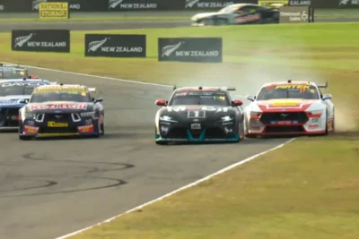 Chaz Mostert's #1 Toyota GR Supra and Brodie Kostecki's #17 Shell V-Power Ford Mustang making side-by-side contact at Ruapuna Raceway during the 2026 ITM Christchurch Super 440, with dust rising from the infield.